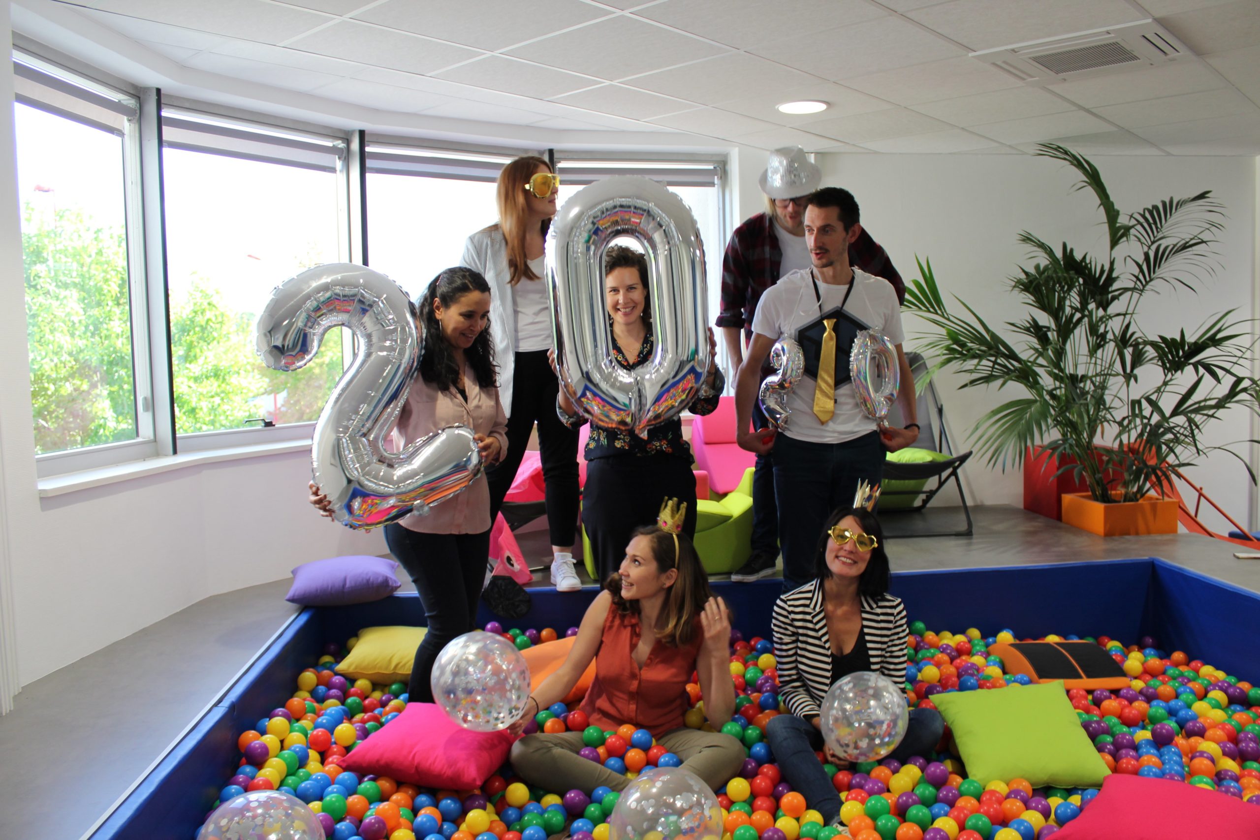 Collaborateurs MV Group dans la piscine à balles avec des ballons et accessoires
